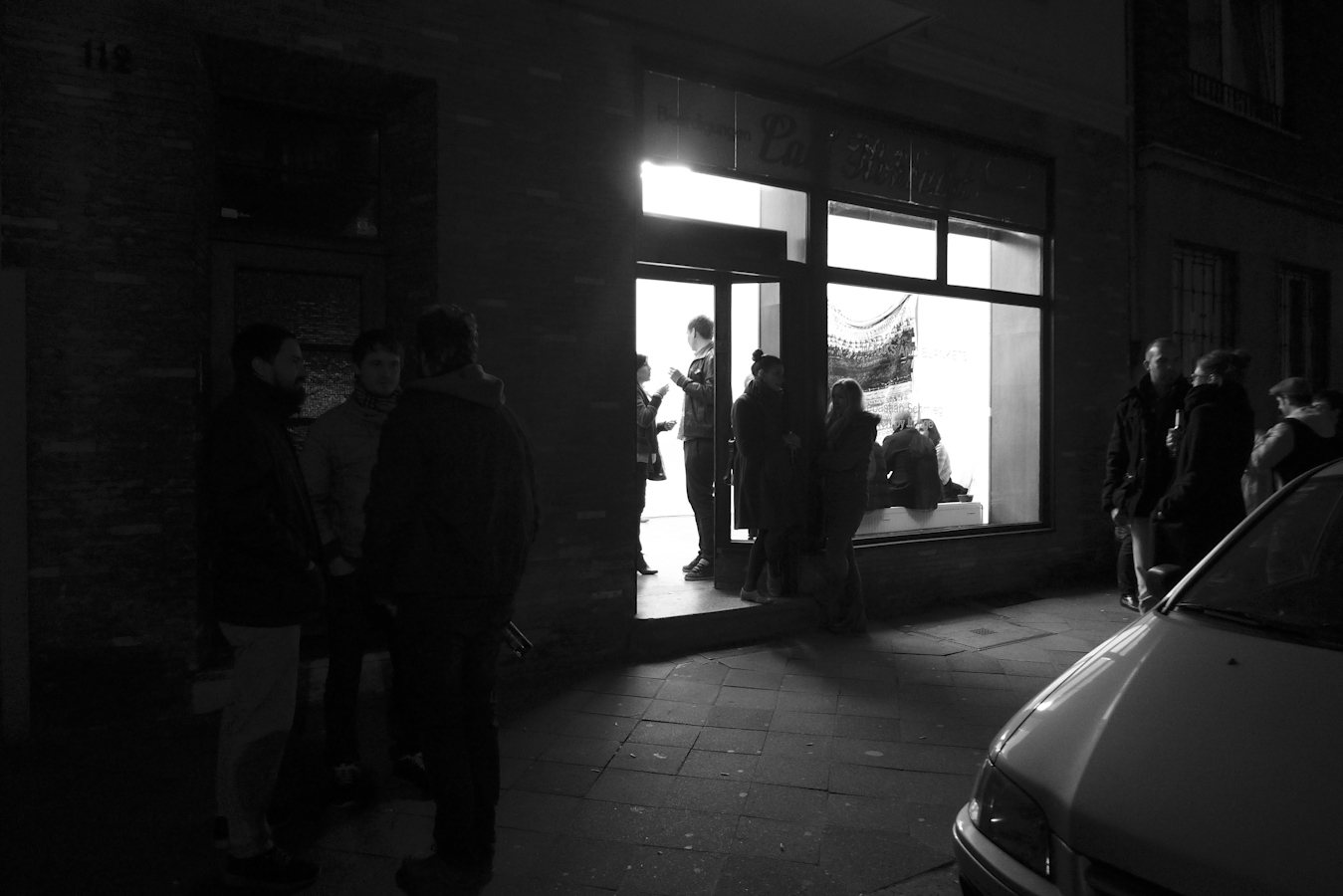 Digital-Soirée 1 — the gallery at night, visitors gathering at the door